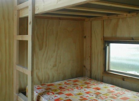 Bare bones interior features two rooms with bunk beds.
