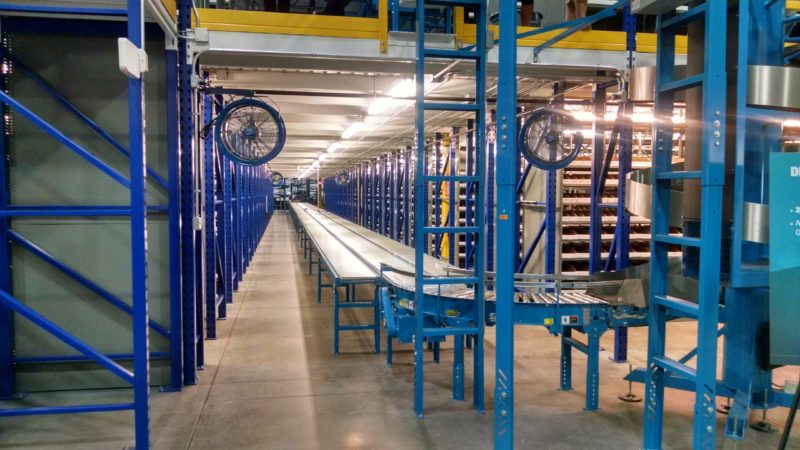 Storage and packing area with conveyor for rolling boxes along