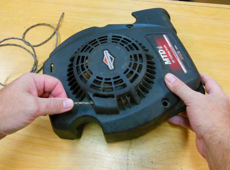 Allowing the new starter cord to retract into the housing.