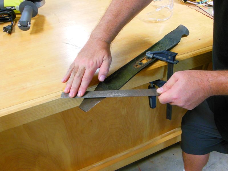 Deburring a lawn mower blade.