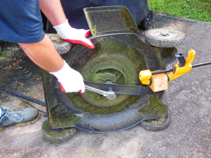 Removing a lawn mower blade.