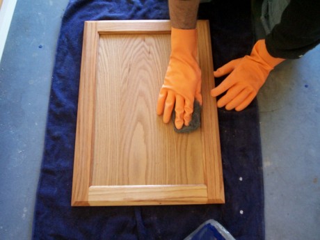 I like to use a 00 steel wool pad to knock down the rough spots on my first coat
